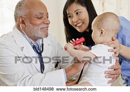 Stock Photo - Doctor examining baby boy. Fotosearch