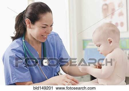 Stock Image - Doctor examining baby in doctor's office. Fotosearch