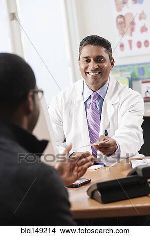 Doctor handing patient prescription in doctor's office View Large Photo Image Picture - Doctor handing patient prescription in doctor's office. Fotosearch
