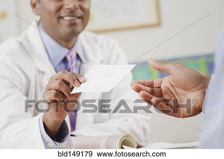 Doctor handing prescription to patient in doctor's office View Large Photo Image Stock Photo - Doctor handing prescription to patient in doctor's office. Fotosearch