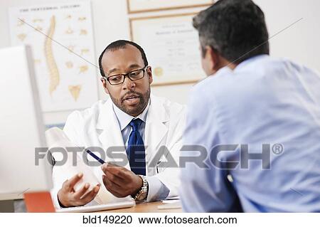 Doctor talking to patient in doctor's office View Large Photo Image Stock Image - Doctor talking to patient in doctor's office. Fotosearch