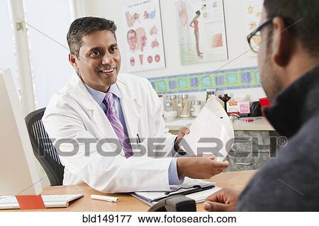 Doctor talking to patient in doctor's office View Large Photo Image Stock Photo - Doctor talking to patient in doctor's office. Fotosearch