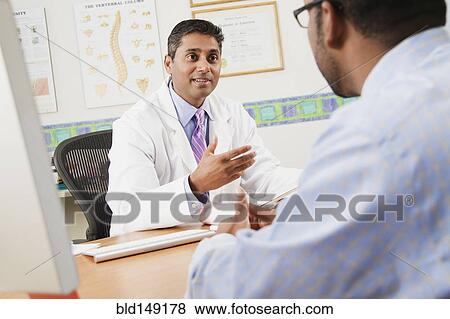 Doctor talking to patient in doctor's office View Large Photo Image Stock Photo - Doctor talking to patient in doctor's office. Fotosearch