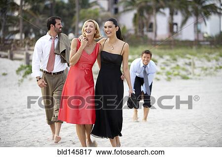 Elegant couples walking on beach together View Large Photo Image Stock Photo - Elegant couples walking on beach together. Fotosearch