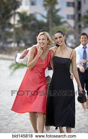 Stock Photo - Elegant couples walking on beach together. Fotosearch