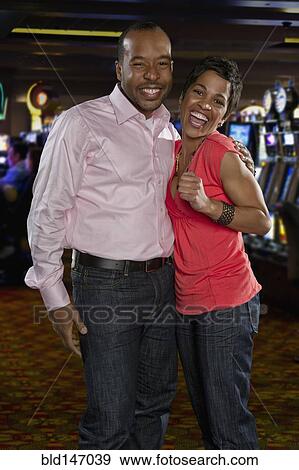 Stock Photo - Excited couple standing in casino. Fotosearch