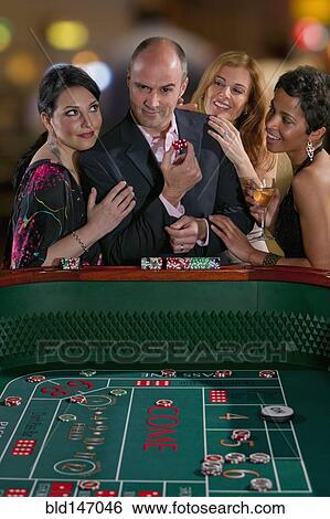 Excited friends gambling at craps table in casino View Large Photo Image Stock Photograph - Excited friends gambling at craps table in casino. Fotosearch