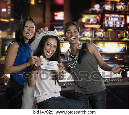 Excited women holding gaming voucher in casino View Large Photo Image Stock Photography - Excited women holding gaming voucher in casino. Fotosearch