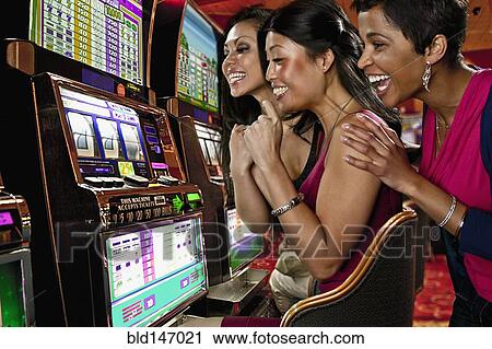 Excited women playing slot machines in casino View Large Photo Image Stock Image - Excited women playing slot machines in casino. Fotosearch