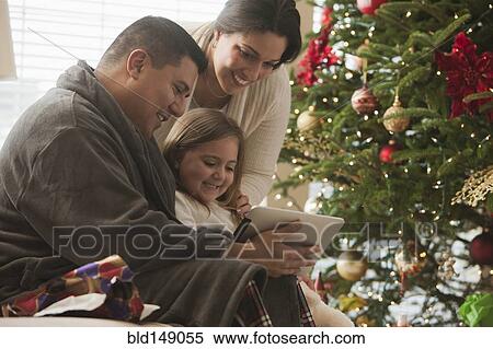 Family looking at digital tablet on Christmas morning View Large Photo Image Stock Photography - Family looking at digital tablet on Christmas morning. Fotosearch