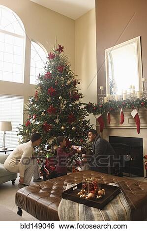 Family opening gifts Christmas morning View Large Photo Image Stock Photograph - Family opening gifts Christmas morning. Fotosearch