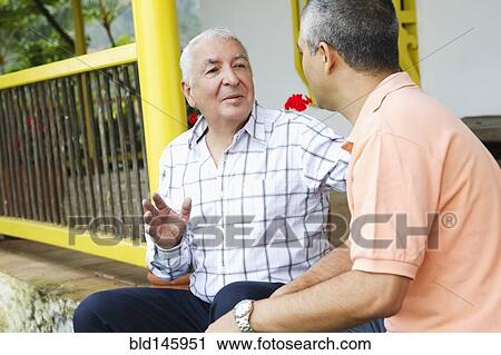 Stock Image - Father and son talking outdoors. Fotosearch