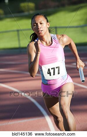 Female relay runner running with baton View Large Photo Image Stock Photograph - Female relay runner running with baton. Fotosearch