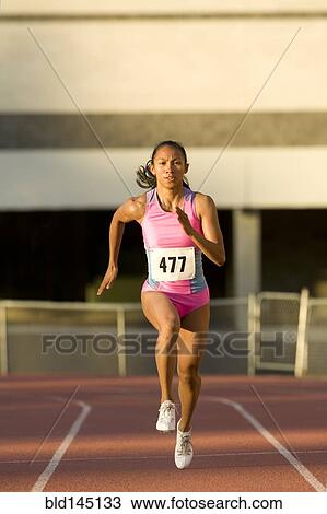 Female runner competing on racetrack View Large Photo Image Stock Image - Female runner competing on racetrack. Fotosearch