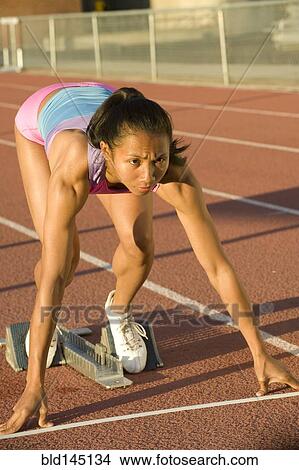 Picture - Female runner preparing to start race on racetrack. Fotosearch