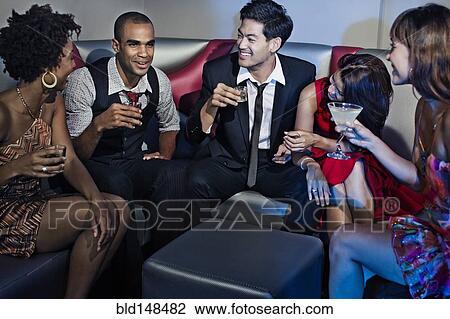 Stock Image - Friends drinking in nightclub. Fotosearch