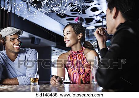 Stock Photo - Friends drinking in nightclub. Fotosearch
