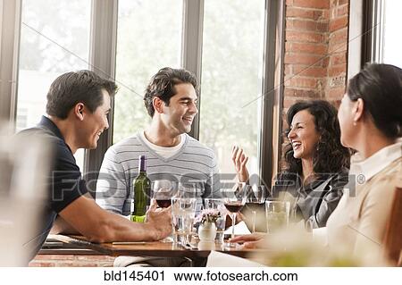 Stock Image - Friends drinking red wine in restaurant. Fotosearch