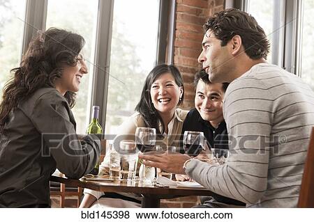 Friends drinking red wine together in restaurant View Large Photo Image Stock Photo - Friends drinking red wine together in restaurant. Fotosearch