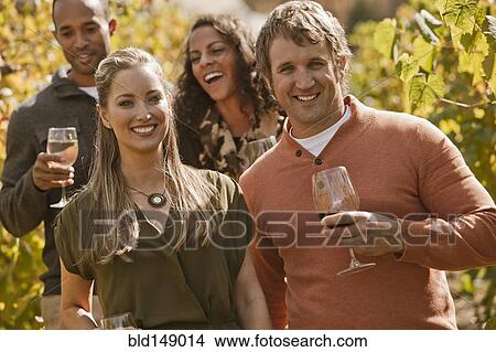 Picture - Friends drinking wine in vineyard. Fotosearch