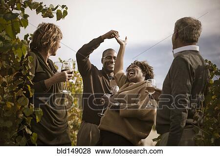 Friends drinking wine in vineyard View Large Photo Image Stock Photo - Friends drinking wine in vineyard. Fotosearch