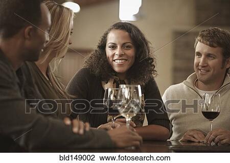 Stock Image - Friends drinking wine together. Fotosearch