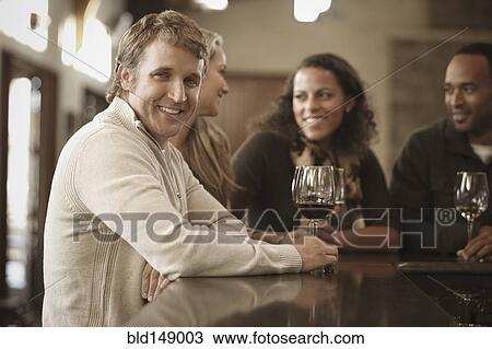 Stock Image - Friends drinking wine together. Fotosearch