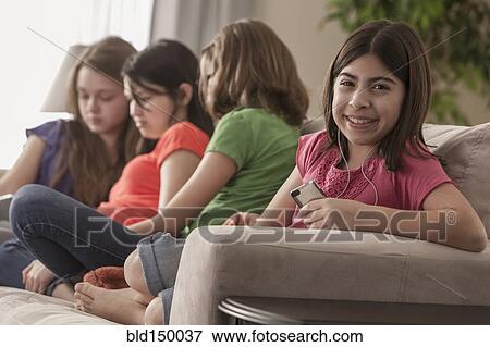 Stock Photo - Friends hanging out on sofa together. Fotosearch