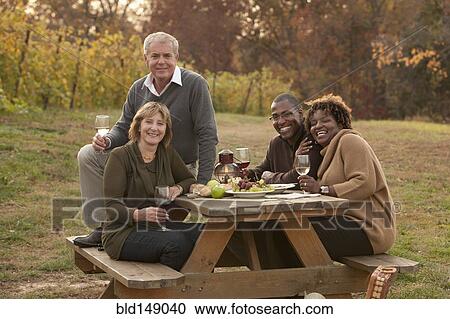 Friends having picnic and drinking wine View Large Photo Image Stock Image - Friends having picnic and drinking wine. Fotosearch