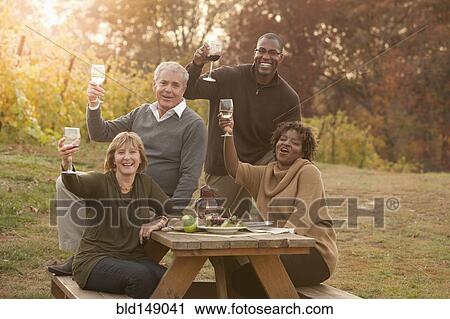 Friends having picnic and drinking wine View Large Photo Image Stock Image - Friends having picnic and drinking wine. Fotosearch