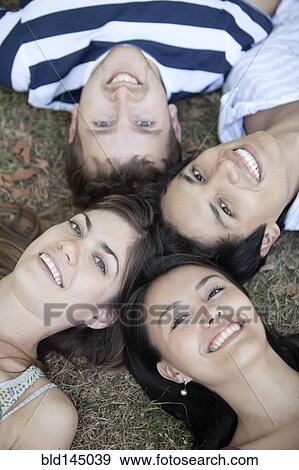 Friends laying in formation in grass View Large Photo Image Stock Photo - Friends laying in formation in grass. Fotosearch