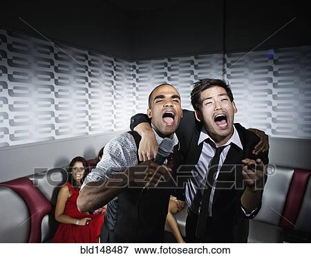 Stock Photo - Friends singing karaoke in nightclub. Fotosearch