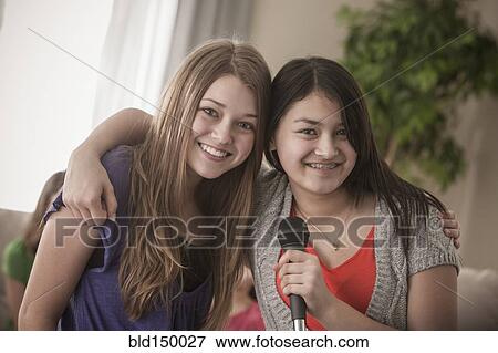 Friends singing karaoke together View Large Photo Image Stock Photo - Friends singing karaoke together. Fotosearch