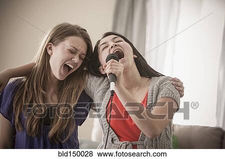Friends singing karaoke together View Large Photo Image Stock Photo - Friends singing karaoke together. Fotosearch