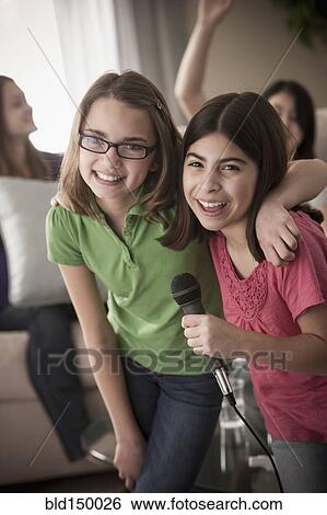 Friends singing karaoke together View Large Photo Image Stock Photograph - Friends singing karaoke together. Fotosearch