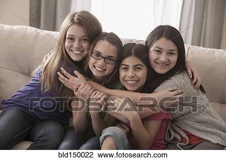 Friends sitting on sofa hugging View Large Photo Image Stock Image - Friends sitting on sofa hugging. Fotosearch