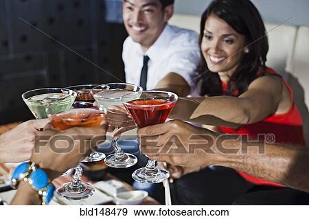 Friends toasting with cocktails in nightclub View Large Photo Image Stock Photo - Friends toasting with cocktails in nightclub. Fotosearch