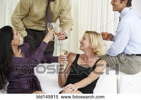 Friends toasting with white wine at party View Large Photo Image Stock Photography - Friends toasting with white wine at party. Fotosearch