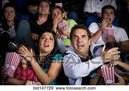 Frightened Hispanic family watching film in movie theater View Large Photo Image Stock Photo - Frightened Hispanic family watching film in movie theater. Fotosearch