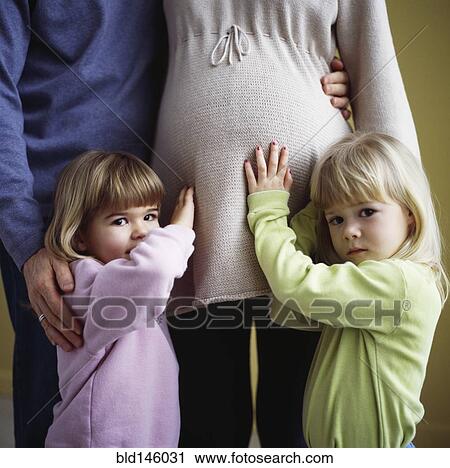 Girls rubbing pregnant mother's stomach View Large Photo Image Stock Image - Girls rubbing pregnant mother's stomach. Fotosearch