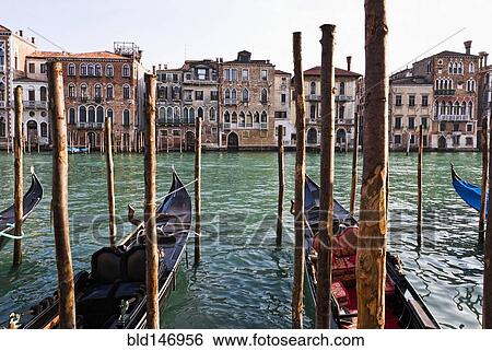 Gondolas moored in canal on wooden posts View Large Photo Image Stock Photograph - Gondolas moored in canal on wooden posts. Fotosearch