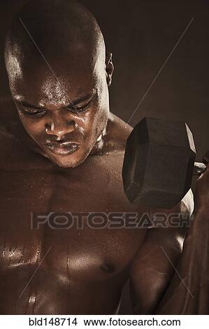 Grimacing African American man lifting weights View Large Photo Image Picture - Grimacing African American man lifting weights. Fotosearch