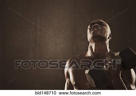 Grimacing African American man lifting weights View Large Photo Image Stock Image - Grimacing African American man lifting weights. Fotosearch