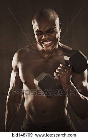 Grimacing African American man lifting weights View Large Photo Image Stock Photo - Grimacing African American man lifting weights. Fotosearch