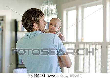 Happy Caucasian father holding baby daughter View Large Photo Image Stock Image - Happy Caucasian father holding baby daughter. Fotosearch