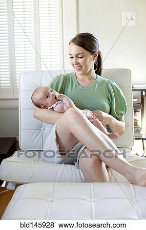 Stock Photo - Happy Caucasian mother holding baby daughter. Fotosearch