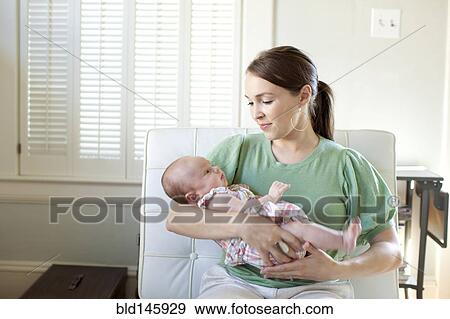 Happy Caucasian mother holding baby daughter View Large Photo Image Stock Photo - Happy Caucasian mother holding baby daughter. Fotosearch