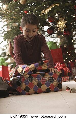 Hispanic boy opening gifts Christmas morning View Large Photo Image Stock Image - Hispanic boy opening gifts Christmas morning. Fotosearch
