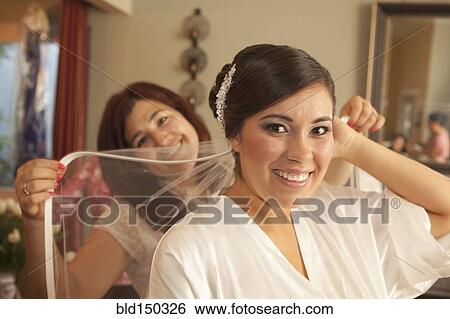 Stock Photograph - Hispanic bride arranging veil. Fotosearch