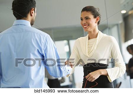 Hispanic business people shaking hands in office View Large Photo Image Stock Image - Hispanic business people shaking hands in office. Fotosearch
